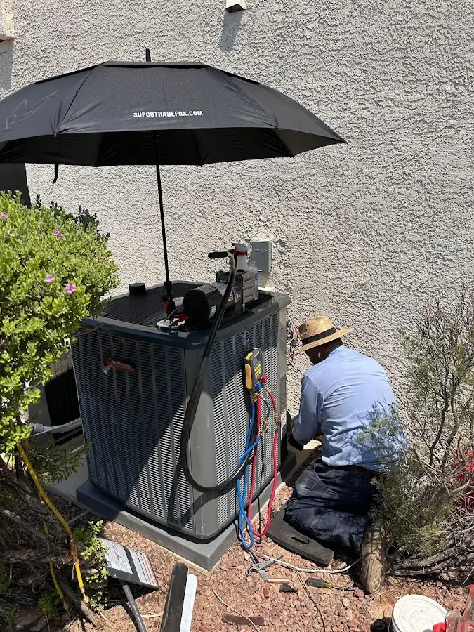 HVAC technician performing outdoor AC maintenance in Mayfield